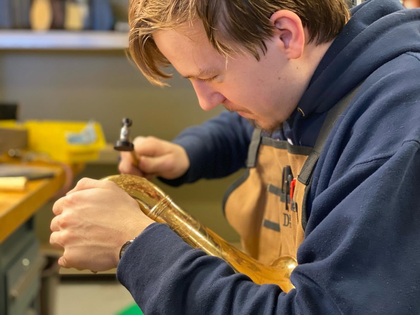 Harrison removing a dent on a saxaphone.